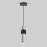 A modern pendant light with a cylindrical concrete shade and a black metal band, hanging from a black cord attached to a round ceiling mount on a plain light gray background.
