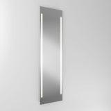 A large rectangular wall-mounted mirror with two vertical LED light strips on either side, set against a plain light gray background.