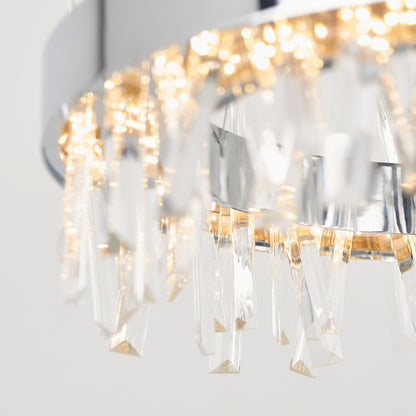 Close-up of the Artika Enchanted LED pendant light featuring hanging crystal prisms and warm lights, casting sparkling reflections against a neutral background.