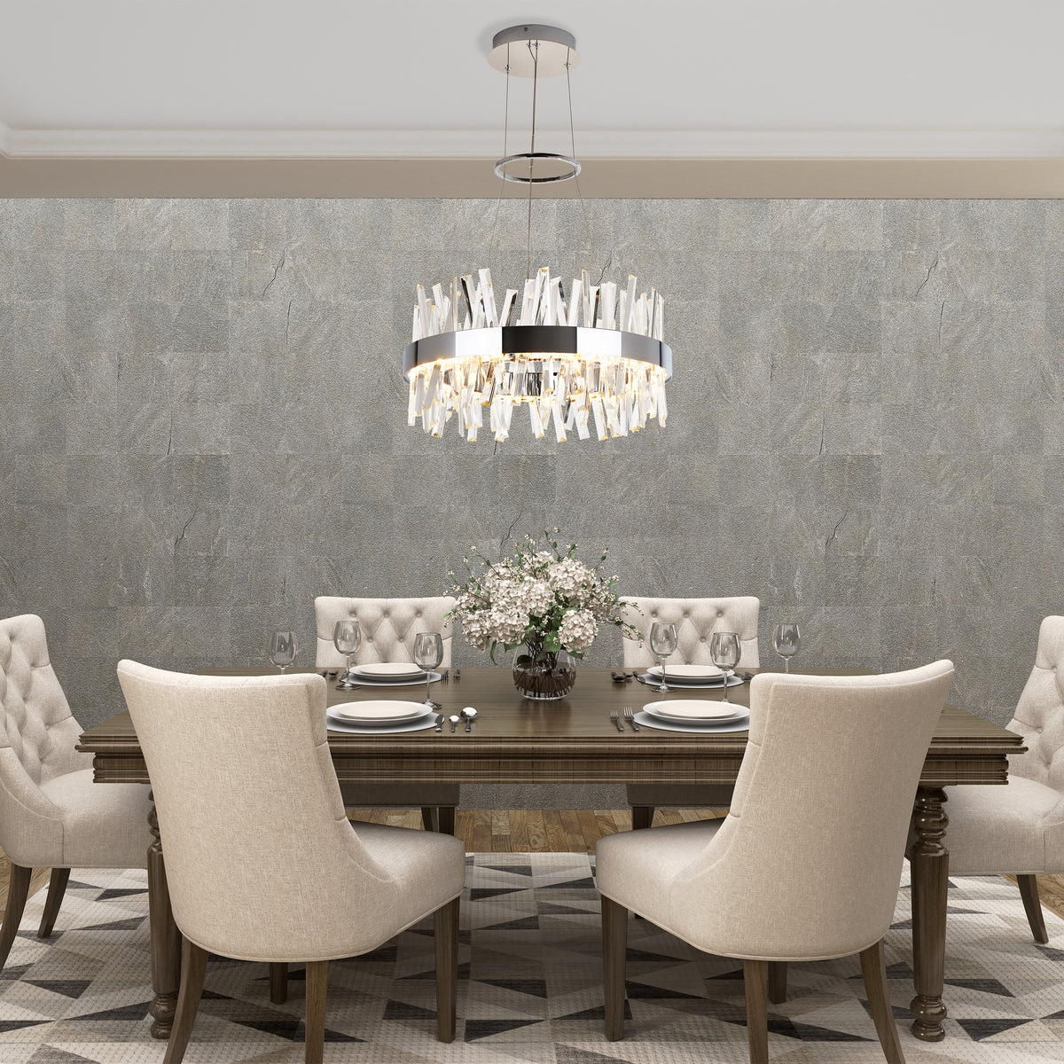 A modern dining room with a dark wood table, six beige upholstered chairs, a glass vase with white flowers, place settings, and a contemporary chandelier hanging above on a gray textured wall.