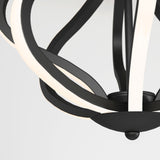 Close-up of a modern black and white light fixture with curved, overlapping bands forming an abstract, spherical design against a plain background.
