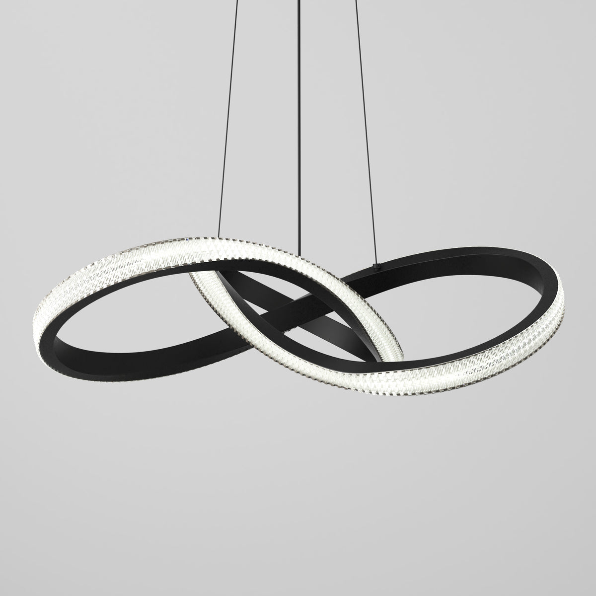 The Artika Morgan LED contemporary pendant light features two interlocking circular rings—one black and one illuminated—suspended by three thin wires against a plain light gray background.