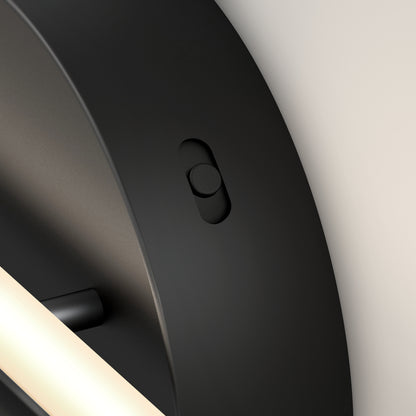 Close-up of the Artika Cisco modern LED bathroom vanity light 5 CCT, a black wall-mounted fixture with a round on/off switch and sleek, minimalistic design against a white wall.