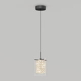 A modern pendant light with a black ceiling mount, a thin black cord, and a cylindrical crystal glass shade emitting a soft, bright glow against a plain light gray background.