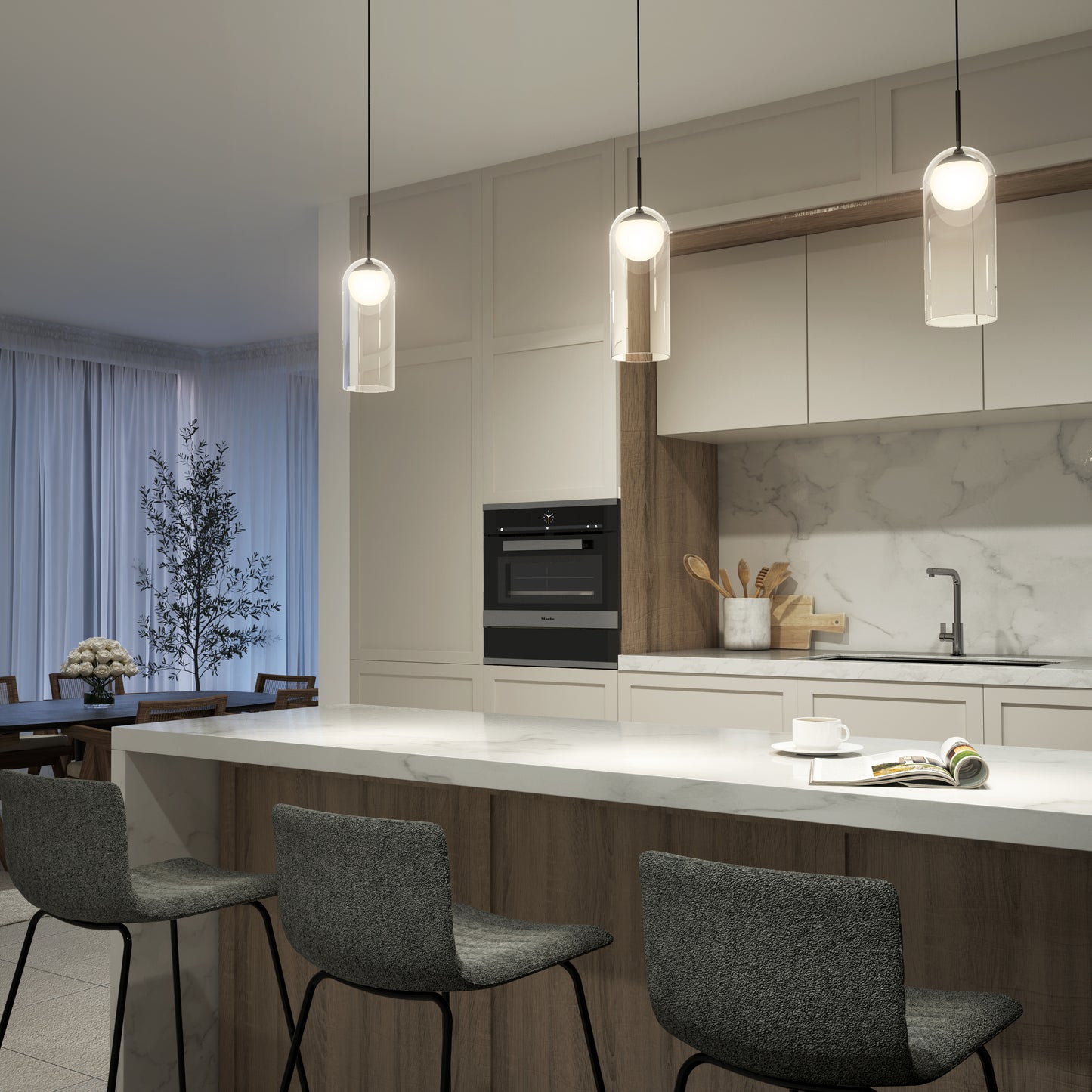 Modern kitchen with white and wood cabinets, a marble backsplash, gray bar stools at an island, and a built-in oven. Overhead, the Artika Mirah LED modern mid-century pendant light (3 CCT) hangs. A dining table and curtained window are in the background.