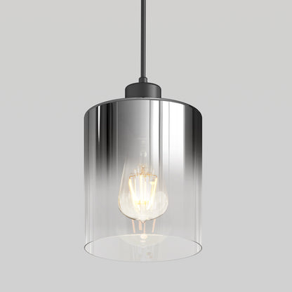 The Artika Haze pendant light features a clear cylindrical glass shade with an exposed bulb, suspended from a black cord, set against a plain light gray background.