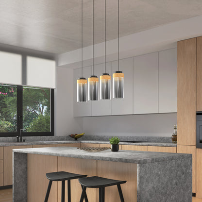 Modern kitchen with light wood cabinets, gray marble countertops, a central island with two black stools, and a large window. The island is decorated with a small plant and illuminated by Artikas Hanson 4-light LED pendant 5 CCT above.