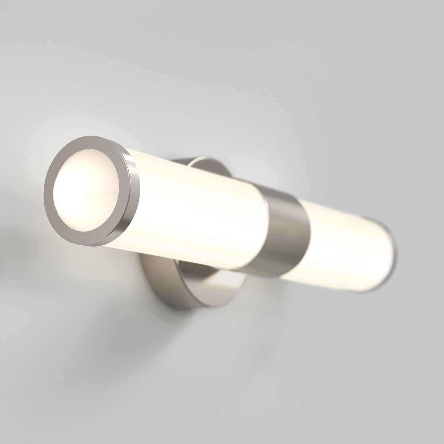 The Adina modern bathroom vanity light 3 CCT by Artika features a sleek wall-mounted design with a cylindrical frosted glass shade and metallic accents, casting a soft, even glow against any light-colored wall.