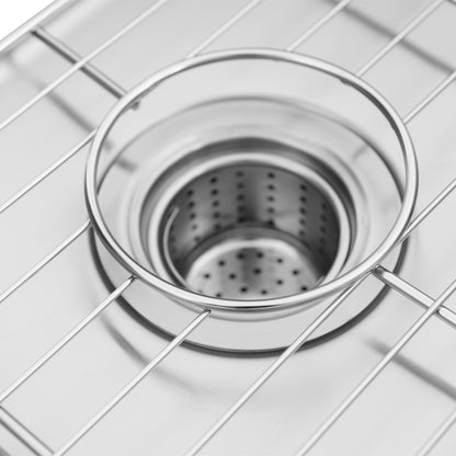 Close-up of the Artika Neoflow single bowl stainless steel sink featuring clean, modern lines, a reflective surface, a metal grid, and a removable drain strainer at the center.