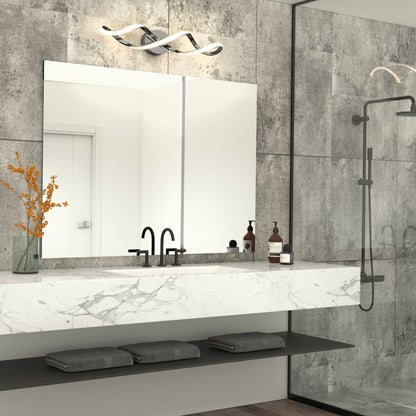 Modern bathroom with a large mirror, marble countertop, black faucet, decorative vase with orange flowers, toiletries, and folded gray towels on a below-shelf. Gray tiled walls, Artika Swirl modern LED vanity light, and glass shower are visible.