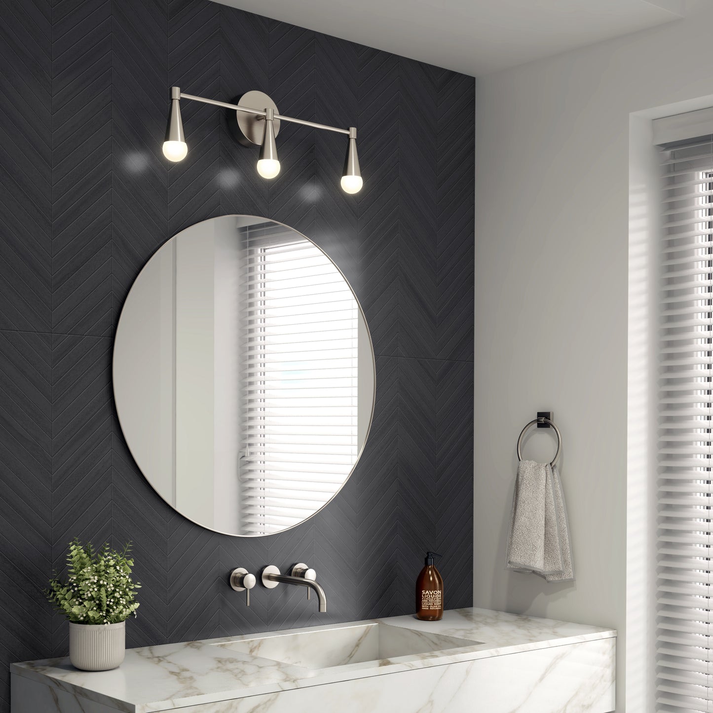 A modern bathroom with a round mirror, marble sink, wall-mounted faucet, black herringbone tile wall, potted plant, hand towel on a ring, window with blinds, and the Artika Wayden LED mid-century bathroom vanity light 3 CCT.