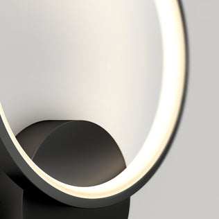 A close-up of the Artika Solis modern LED indoor-outdoor wall light 5 CCT shows its circular shape, sleek black base, and minimalistic design glowing softly against a plain light gray background.