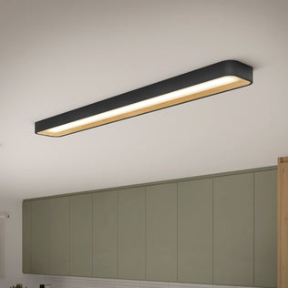 An Artika Alton 48 in. LED flush mount light with a black and wood finish is installed above olive green kitchen cabinets, softly illuminating the space below.