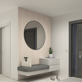 A modern entryway features Artika’s Panolok 30.67 ft wall panel kit, a floating gray bench, round mirror, small white drawer with potted plant, shopping bag, and sneakers next to a dark door.