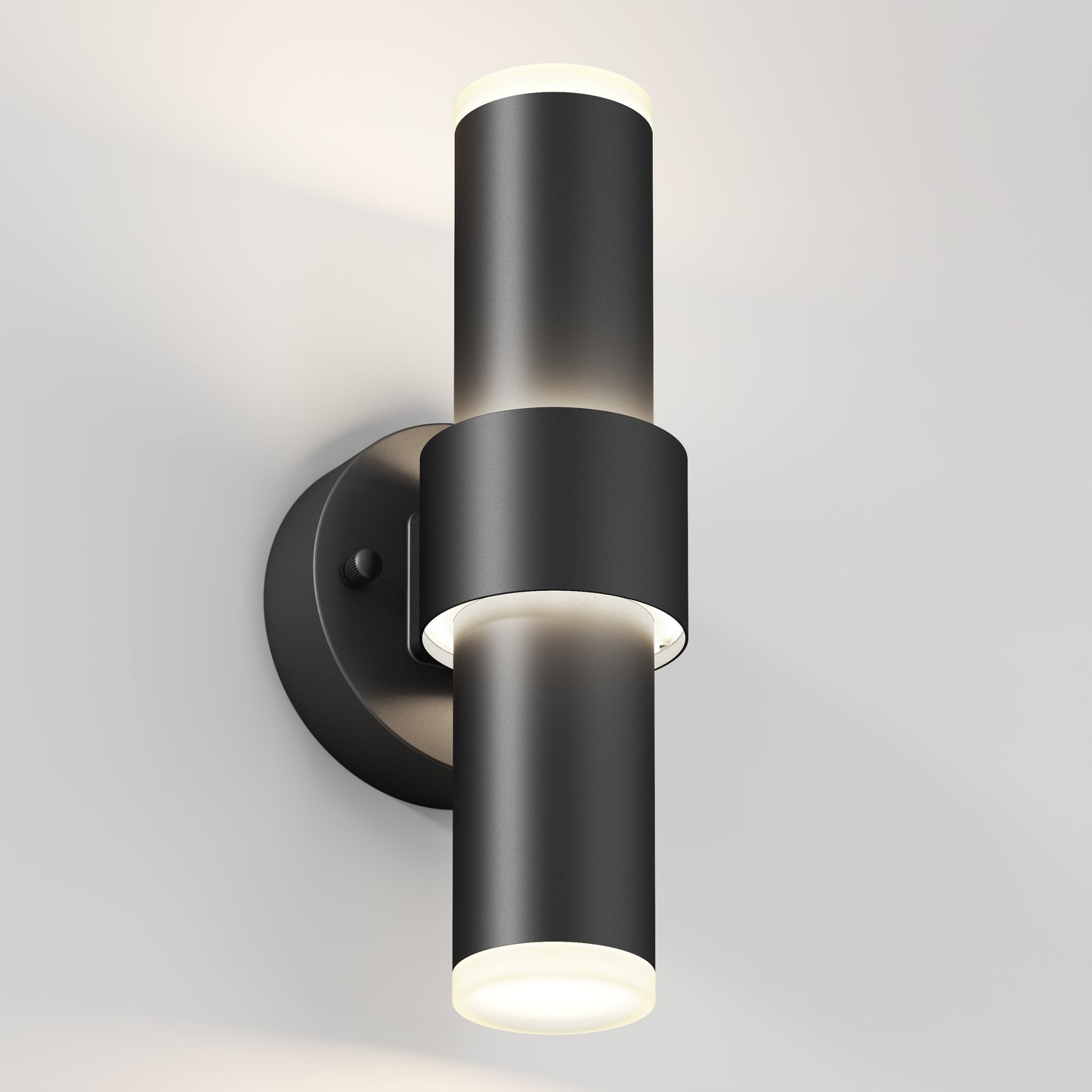The Artika Dani modern LED indoor-outdoor wall light 5 CCT is a sleek black cylindrical sconce with up-and-down lights on a round base, shown mounted on a light-colored wall.