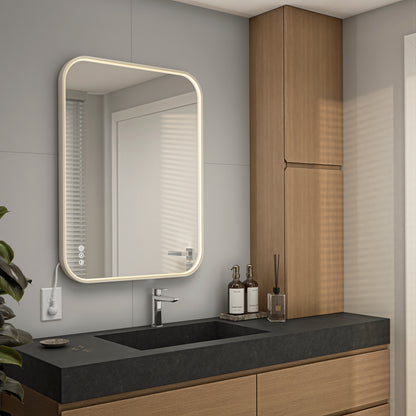 Modern bathroom with the Artika Royce Dimmable LED Mirror (3 CCT, horizontal/vertical mount) above a black countertop sink, featuring wooden cabinetry, neutral tones, minimalist decor, and accessories like bottles and a reed diffuser.