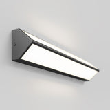 A modern, triangular wall-mounted LED light fixture with a matte black frame and a frosted white panel, glowing softly against a plain light gray wall.