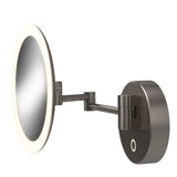 A round, wall-mounted, adjustable vanity mirror with an LED light ring around the edge and a brushed metal finish. The mirror is attached to an extendable arm connected to a circular wall mount.