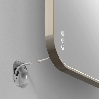 A close-up of the Artika Royce Dimmable LED Mirror, 3 CCT, mounted on a wall with touch buttons and two exposed wires at the back. The mirror allows adjustable colour temperature for personalized lighting.