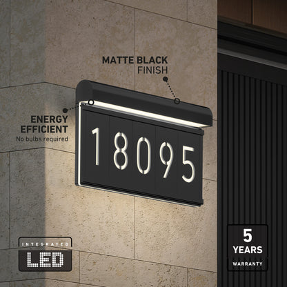 A modern black LED house number sign with “18095” illuminated, mounted on a stone wall. Features include a matte black finish, energy efficiency (no bulbs), and a 5-year warranty.