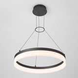 Modern circular pendant light fixture with a black frame and glowing white inner ring, suspended from the ceiling by three thin wires attached to a round ceiling mount. The design is minimalist and contemporary.