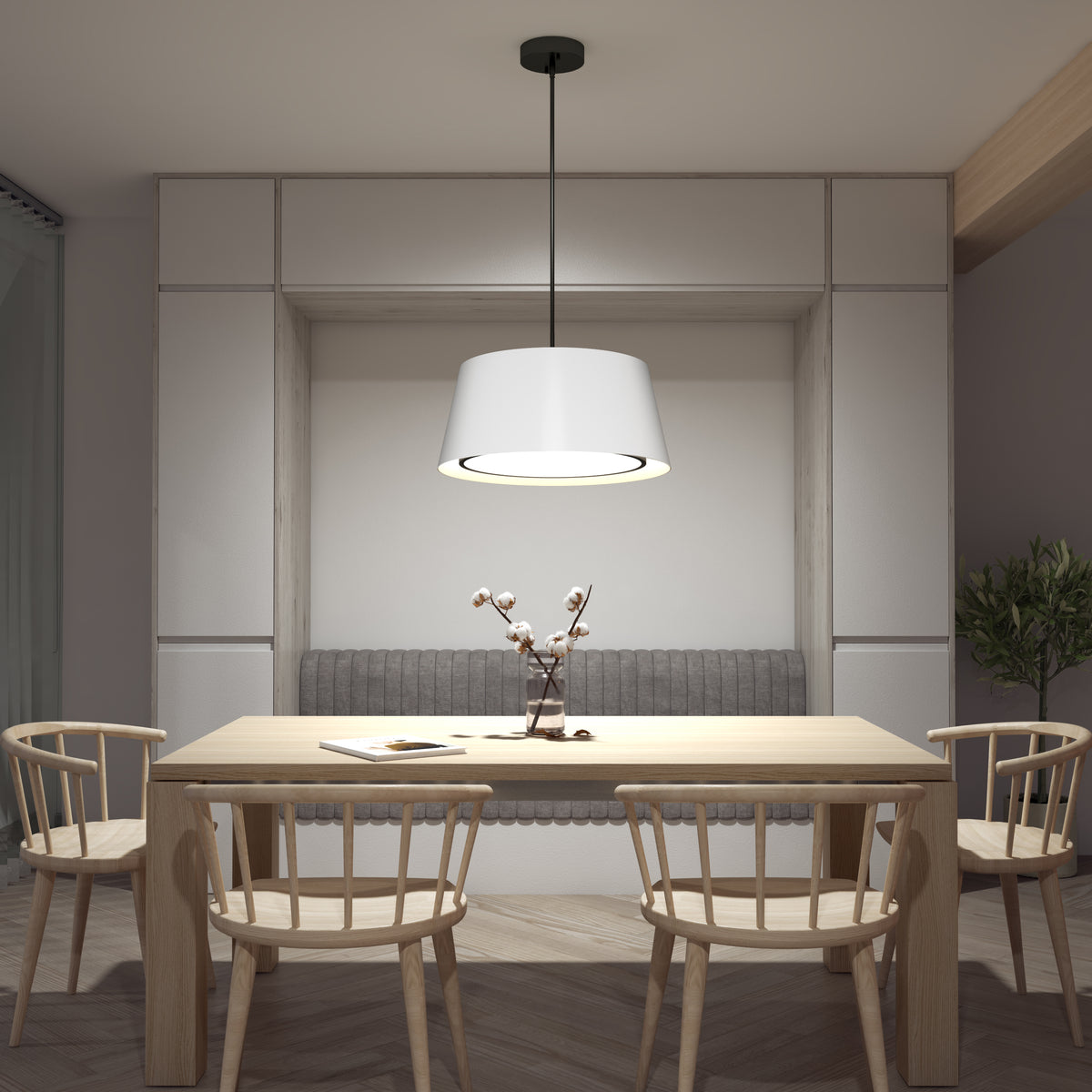 A modern dining area with a wooden table, four matching chairs, a gray-upholstered bench, the Artika Cappa LED pendant light 3 CCT as the centerpiece, and a minimalist vase with branches on the table.