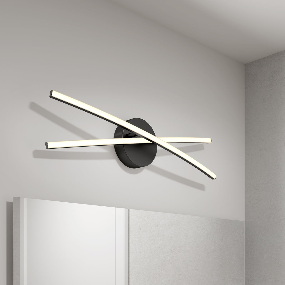 Modern wall light with two curved LED bars crossing over a round black base, mounted above a bathroom mirror on a white wall.