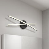 Modern wall light with two curved LED bars crossing over a round black base, mounted above a bathroom mirror on a white wall.