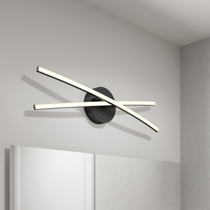 The Orly modern LED bathroom vanity light 3 CCT by Artika features two sleek, curved LED bars intersecting at a black circular base, creating a stylish wall-mounted fixture ideal for mounting above a mirror on a white wall.