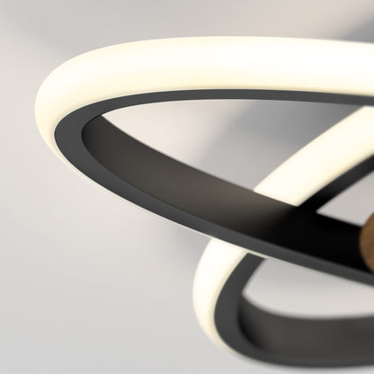 Close-up of the Artika Atomic 15 in. LED flush mount light, featuring intertwined black and white rings for a sculptural, modern look against a plain background. Selectable 5 CCT settings offer customizable lighting.