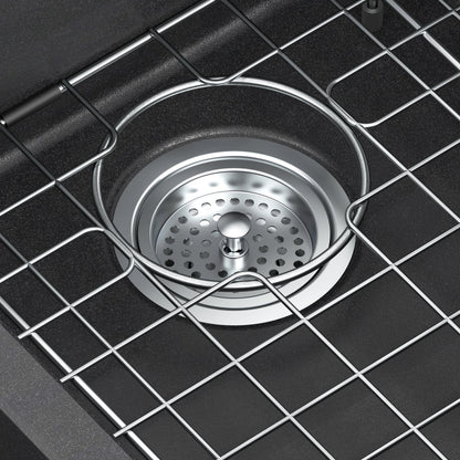 Close-up of the Artika Baycrest 33 in. Double Bowl Kitchen Sink in black, featuring a strainer and protective wire rack above the drain.