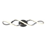 A modern wall-mounted LED light fixture with two intertwined, wavy metallic arms and a circular black base, creating an elegant and contemporary design.