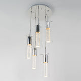 A modern ceiling light fixture with five cylindrical glass pendants, each containing bubbles and suspended at different lengths from a round white base, emits a soft white glow.