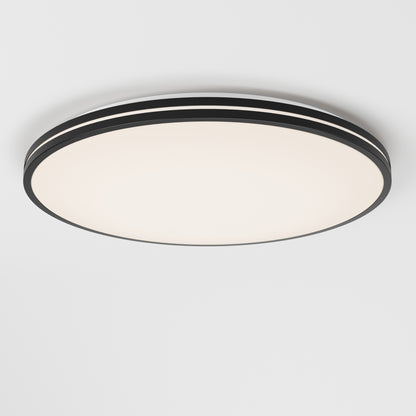 The Artika Athos 21 in. LED flush mount light features a modern round design with a black rim and smooth frosted white surface, seamlessly mounted on a white ceiling, and comes with a remote for easy control.