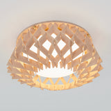 A modern ceiling light fixture with a geometric, lattice-patterned wooden shade, allowing light to diffuse softly through the angled wooden slats. The light emits a warm, inviting glow.