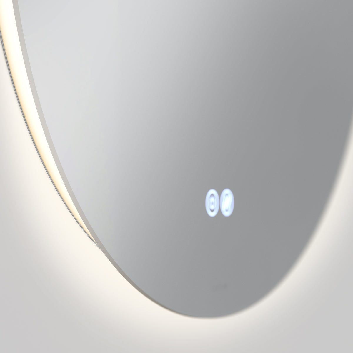 A close-up of a modern round mirror with a soft backlight along the edge. Two illuminated touch buttons are visible on the surface, reflecting a minimalist and sleek design.