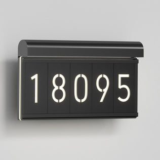 The Artika Bowen modern LED outdoor address wall light (5 CCT) displays illuminated house numbers 18095 on a light gray wall, offering a stylish and contemporary look to your home's exterior.