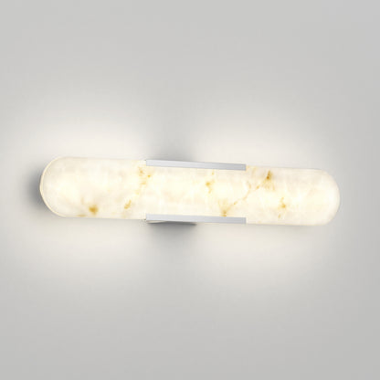 The Artika Selena 3 CCT LED bathroom vanity light features a modern cylindrical frosted glass shade with a marble effect, mounted horizontally on a light gray wall with two sleek metallic brackets to emit soft, warm illumination.