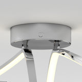Close-up of a modern ceiling light fixture with a shiny chrome base and curved, illuminated LED arms extending outward, set against a plain white ceiling.