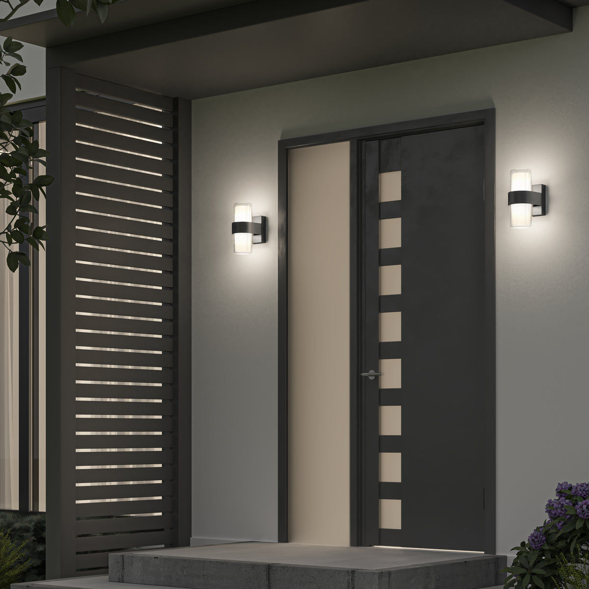 A modern front door with vertical rectangular cutouts is flanked by two Artika Colton modern LED indoor-outdoor wall lights (5 CCT). To the left is a slatted privacy screen, steps lead to the entrance, and plants are visible nearby.