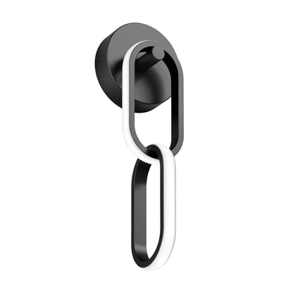 The Artika Catena modern LED wall sconce 5 CCT features two interlocking oval loops—one black and one illuminated white—mounted on a circular black base for a sleek, contemporary look.